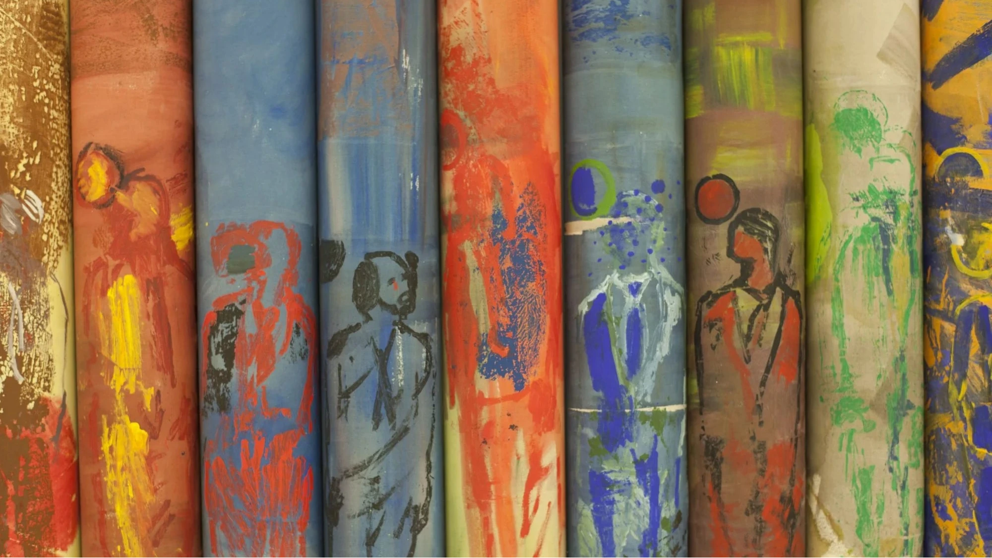 Frontale Nahansicht auf neun vertikal aneinanderstehende Rollenbildern in den Farbtönen: Blau, rot, gelb, grün, braun. Deutlich zu erkennen: Die selbe variierende männliche "Figur mit wandernder Scheibe vor dem Kopf".